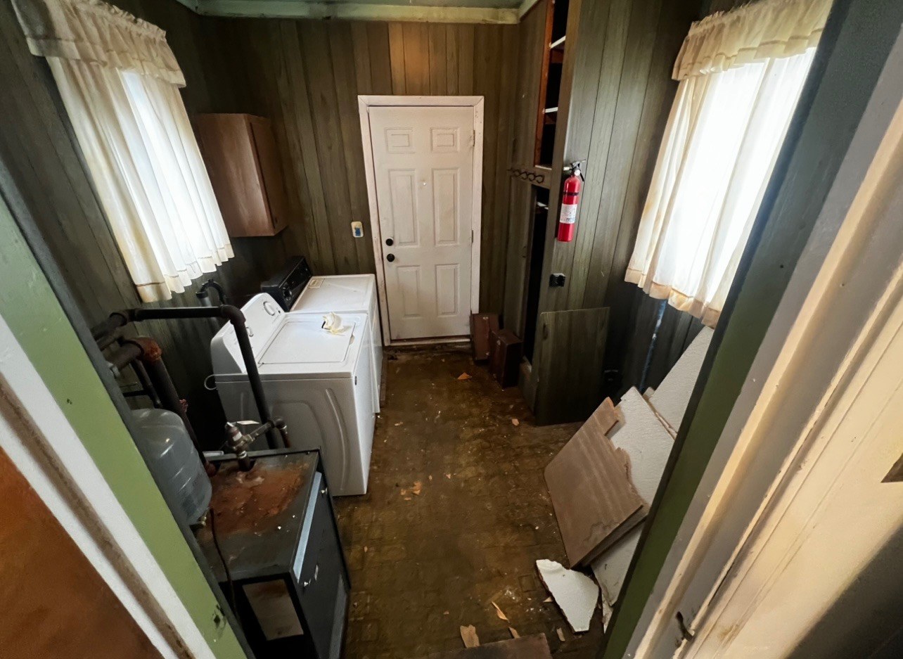 Old utility room with wood paneling before remodel